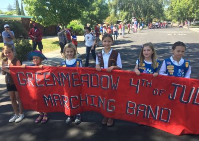 Girls Scouts carry the banner for the Greenmeadow Band 4th July
